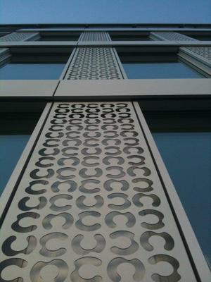 Lochblechfassade nach Maß mit einer Sonderlochung (in Hufeisen-Form), für ein Bürogebäude in der Lausanne, Schweiz